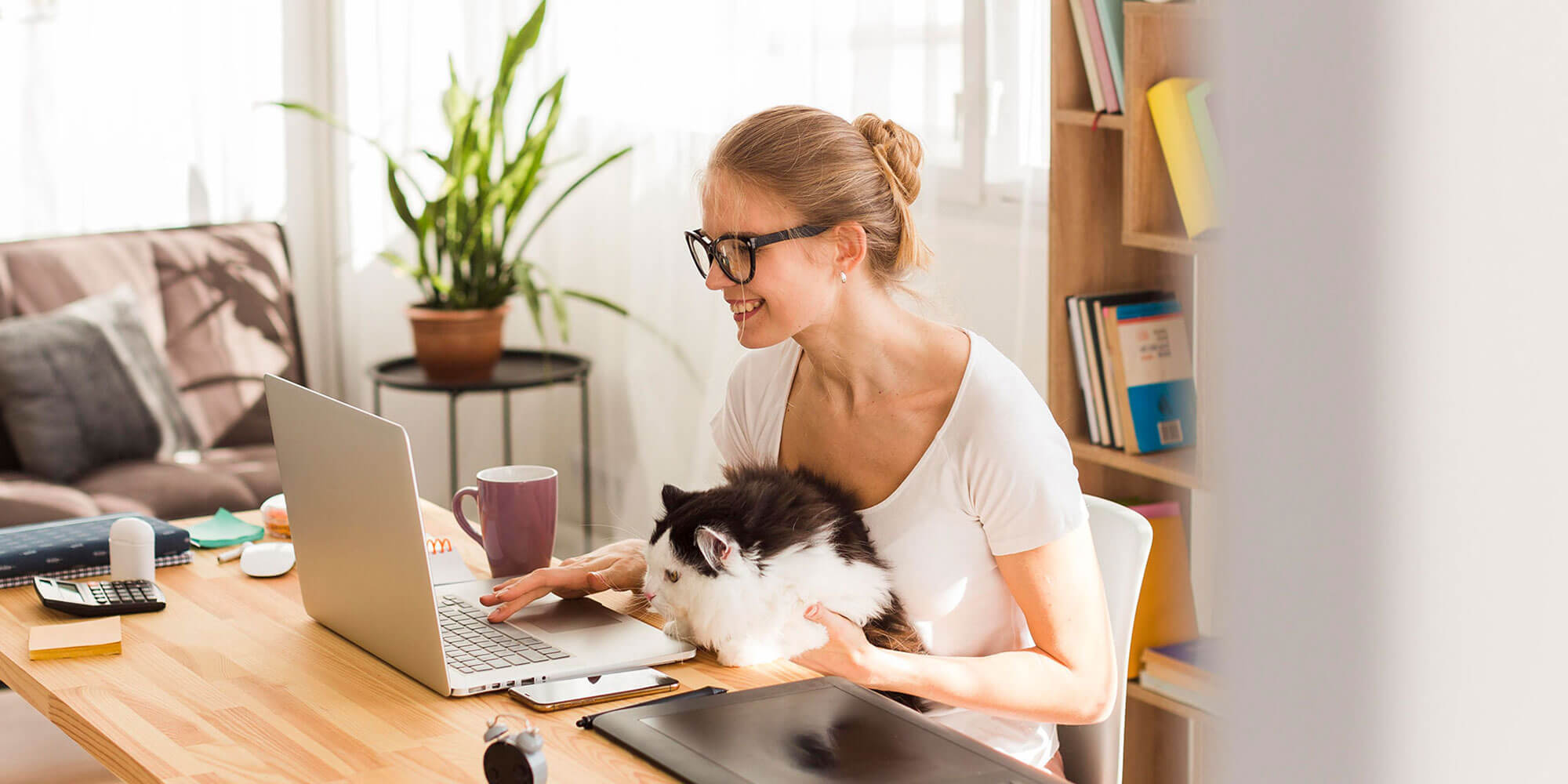 femeie care lucrează la biroul de acasă alături de pisică